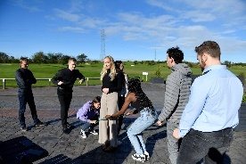 A group of graduates taking part in an outdoor team activity