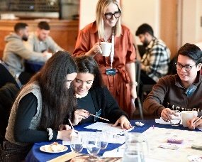 Graduates collaborating on a hands-on task at a table