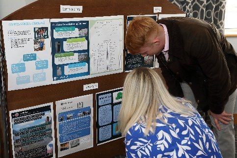 Colleagues viewing a display of project posters