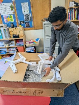 A graduate assembling a large structure as part of a volunteering project